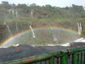 A full rainbow over the falls on the Brazilian side with trees as the backdrop