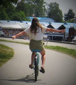 Me riding the bike down a paved seawall at Stanley Park