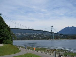 The view of Lions Gate Bridge over the sea with a mountain in the background