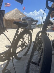 two bikes resting in the sand on the beach